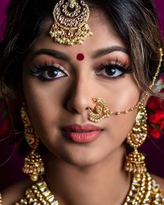 a woman with makeup and jewelry on her face