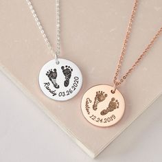 two personalized necklaces with baby footprints and date engraved on the front, one in gold or silver