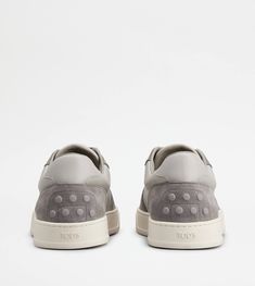 A sporty and sophisticated taste characterizes these sneakers with basketball-inspired upper, and side Tod's logo. Crafted in calfskin suede with smooth leather inserts, they come with a rubber outsole with embossed rubber pebbles. Grey Sneakers, Back To Black, Smooth Leather, Grey And White, Calf Skin, Basketball, Sneakers, Grey, Leather