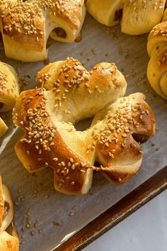 sesame seed bagels are lined up on a baking sheet