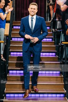 a man in a suit and tie standing on stairs