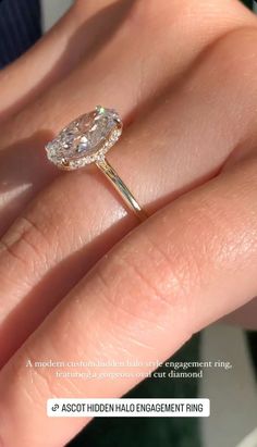 a woman's engagement ring with an oval diamond in the center, on her finger