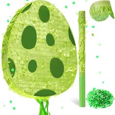 a green object with black dots on it next to a stick and some other items