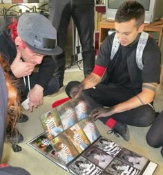 a group of people sitting on the floor with dvd's in front of them