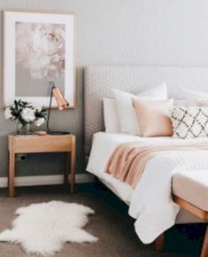 a bedroom with a bed, nightstand and pictures on the wall above it that is decorated in neutral colors