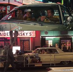 two different shots of people in cars at night and on the street with neon signs