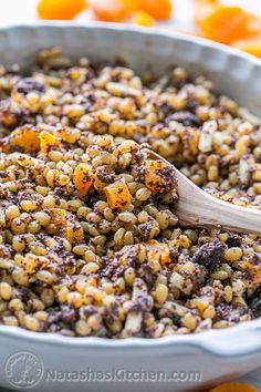 a casserole dish filled with brown rice and oranges in the background, ready to be eaten