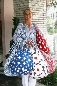 a woman is holding several bags in her hands