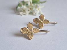 "Delicate solid gold flower drop earrings, romantic jewelry earrings for women, available in 9k yellow gold, 14k yellow, white, or rose gold. Elegant handmade gold drop earrings feature each a four petals flower with a unique, organic texture. They are available in 9k yellow gold, 14k yellow, white, or rose gold.  These graceful and romantic gold earrings are excellent for everyday earrings and special occasions. Get this elegant earring set and add nature-inspired elegance to your look. Item de Delicate Gold Flower Earrings In Sterling Silver, Delicate Hypoallergenic Yellow Gold Flower Earrings, Hypoallergenic Yellow Gold Drop Flower Earrings, Delicate Yellow Gold Earrings With Lever Back, Drop Gold Earrings, Gold Flower Earrings, Romantic Earrings, Earrings Nature, Romantic Jewelry