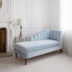 a blue couch sitting in front of a fireplace