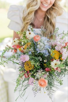 a woman holding a bouquet of flowers in her hands