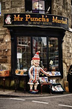 a store front with a statue of a clown outside