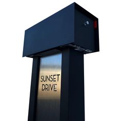 a sign that says sunset drive on the side of a black structure with a red light at the top