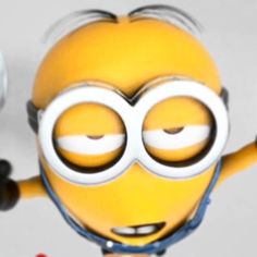 a yellow minion with big eyes and headphones is holding up his arms in the air