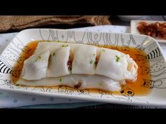 a white plate topped with dumplings covered in sauce