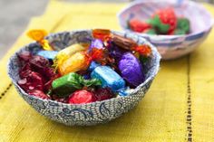 two bowls filled with candy sitting on top of a table