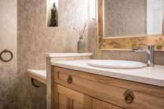 a bathroom with a sink, mirror and towel rack