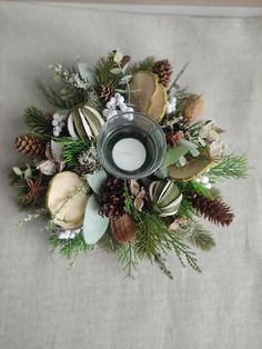 a candle that is sitting on top of some pine cones and other things around it