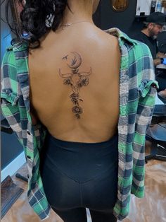 the back of a woman's body with a tattoo on her upper and lower back