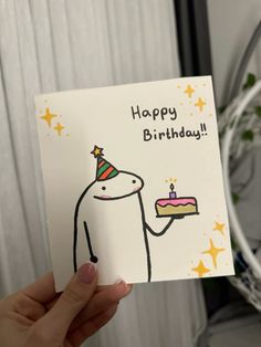 a person holding up a birthday card with a cake on it and the caption happy birthday