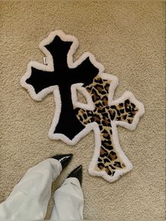 someone is laying on the floor next to a cross and leopard print patched onto it