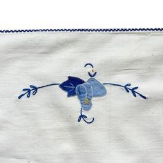 an embroidered cloth with blue flowers on it