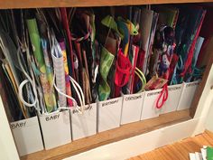 a wooden shelf filled with lots of different colored umbrellas and papers on top of it