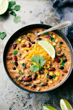 a bowl of mexican soup with beans, cheese and cilantro