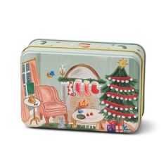 a green tin with a christmas scene on the side and a red chair next to it