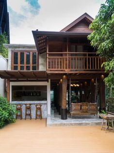 a large wooden house sitting on top of a lush green hillside