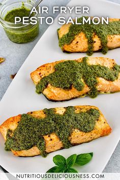 grilled salmon with pesto sauce on a white platter