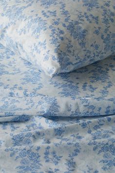 two blue and white pillows sitting on top of each other