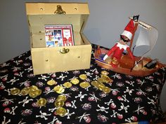 a toy pirate ship and some gold coins on a bed with a santa clause hat