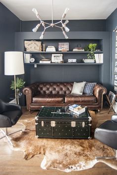 a living room filled with furniture and a cowhide rug