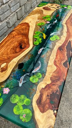 the table is made out of wood and has water lilies on it, along with green leaves