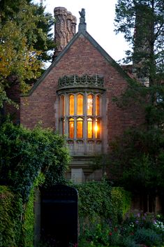 an old brick building with windows lit up by the light of the candle in the window