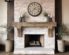 a fireplace with a clock above it and some potted plants on the mantel