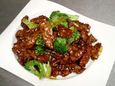 beef and broccoli with sauce on a white plate