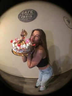 a woman holding a cake in front of her face