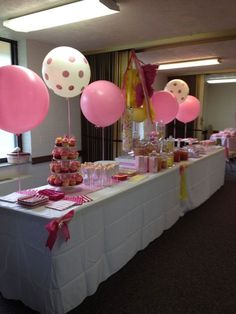 a table topped with lots of pink and white balloons