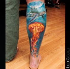 a man's leg with an octopus and jellyfish tattoo on it, while he is standing in front of the camera