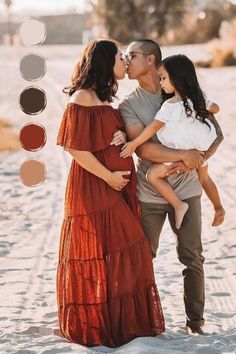 a man and woman kissing while holding a baby in the sand with color swatches