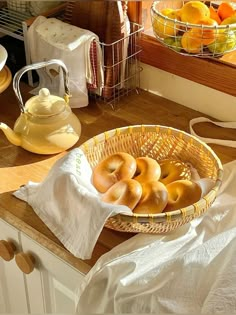 a basket filled with donuts sitting on top of a counter next to oranges