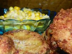 fried corn on the cob and potatoes in a glass bowl next to another dish