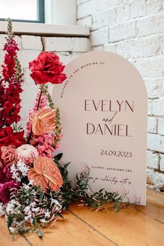 flowers and greenery are placed next to a wedding sign