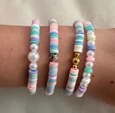 three bracelets with different colors and designs on them, one has a gold charm