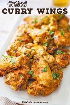 grilled curry wings on a white plate with text overlay that reads grilled curry wings