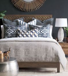 a bedroom with a bed, nightstand and mirror on the wall above it is decorated in blue and white