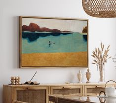 a painting hanging on the wall above a dining room table