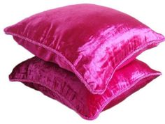 two pink velvet pillows stacked on top of each other in front of a white background